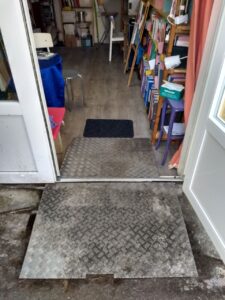 Rampe d'accès pour la porte principale. Deux plaques en métal antiglisse de chaque cote du pas de porte.